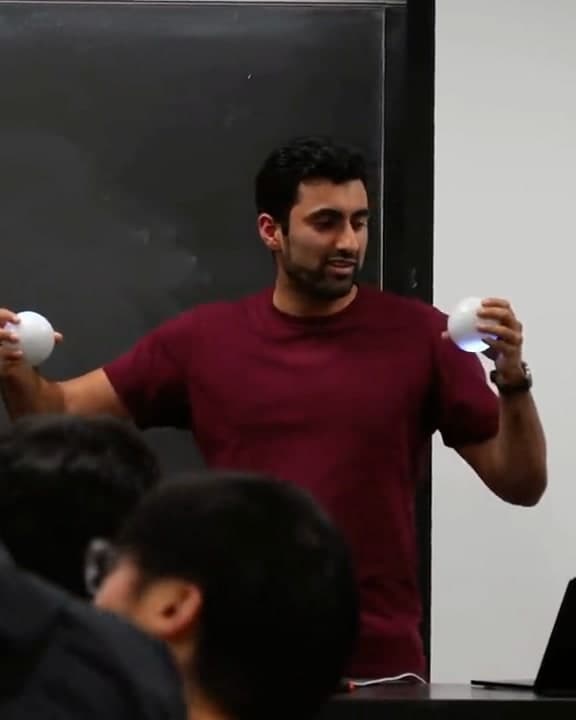 An instructor demonstrating entangled Qubis to a lecture hall