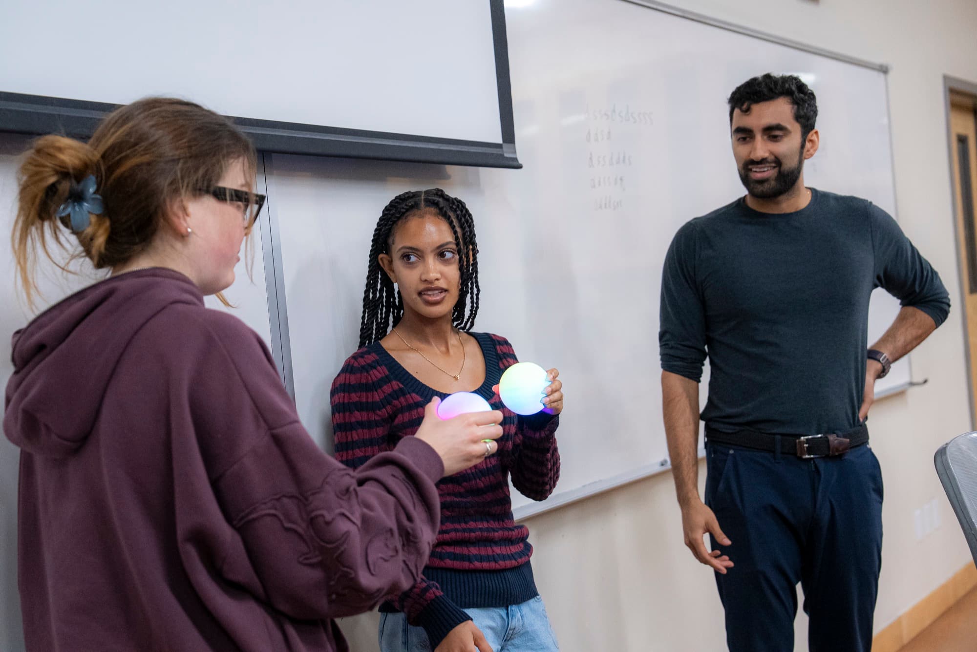 Sohum Thakkar demonstrating the singlet state with two participants holding Qubis