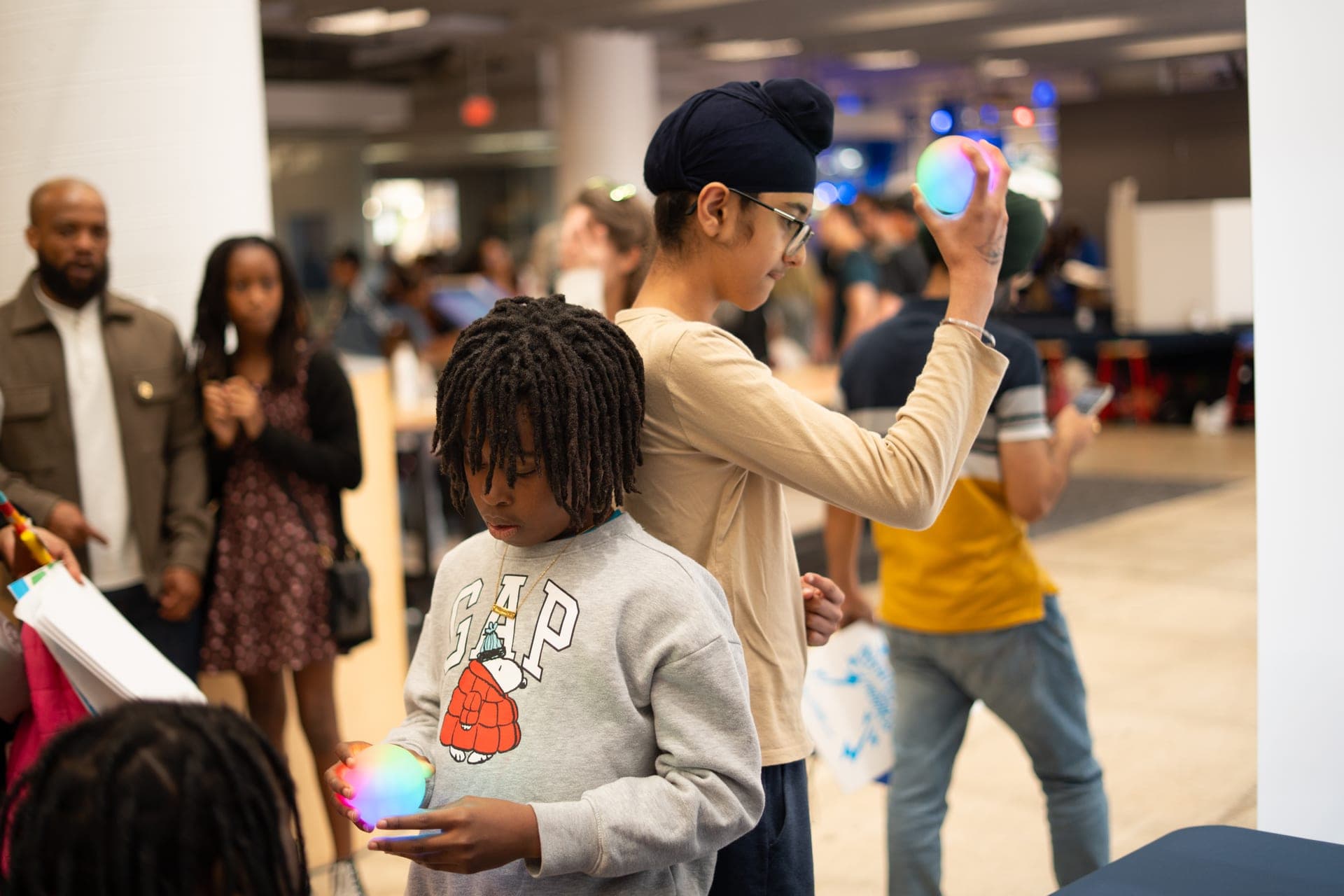 A child holding a glowing Qubi at the KID Museum quantum booth